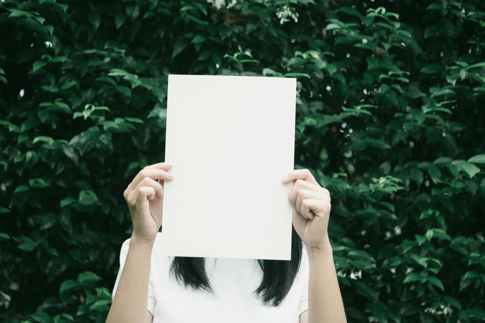 Woman covering her face with paper representing online privacy protection